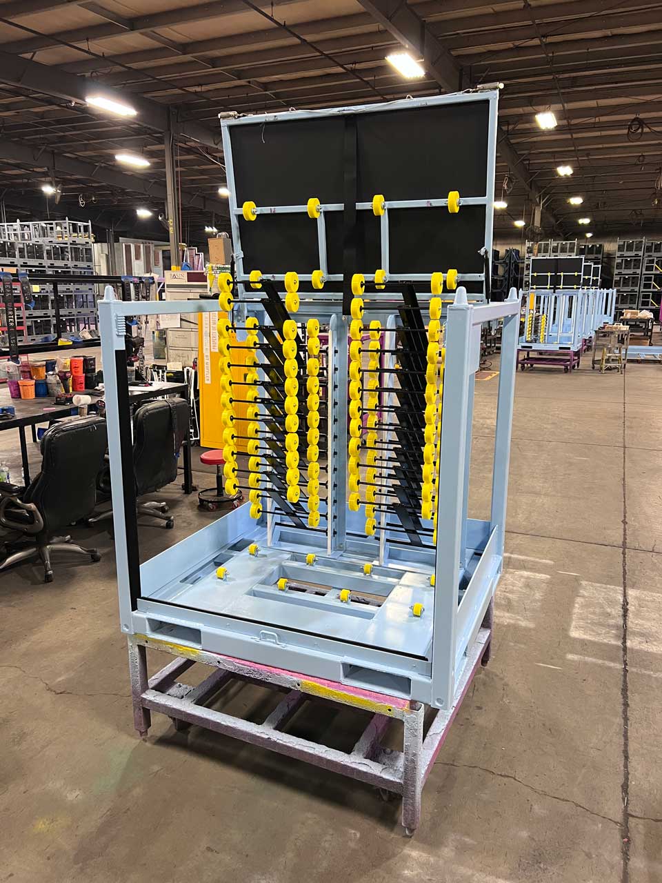 A complex steel rack with moving compartments to hold panes of glass.