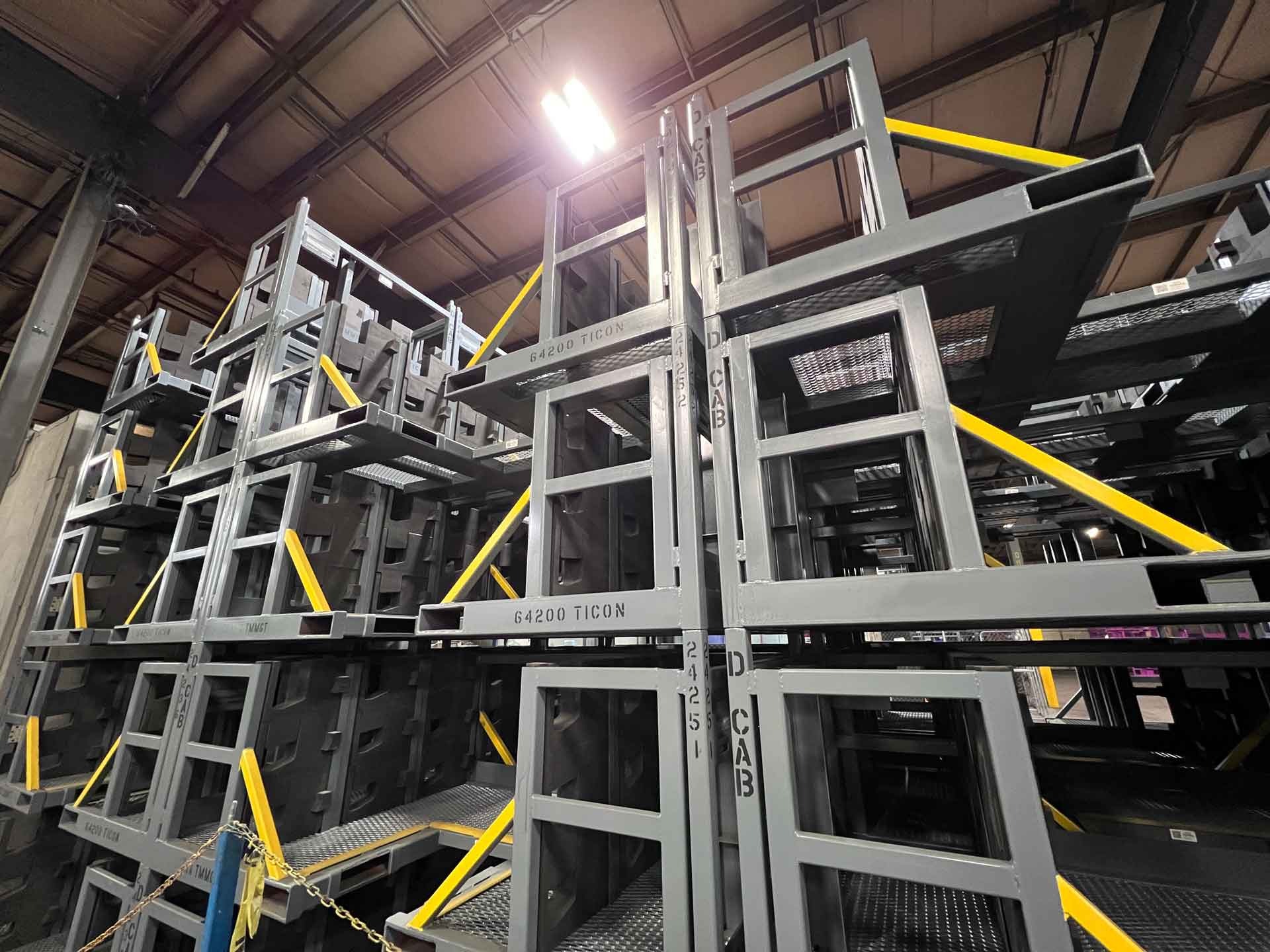 large-steel-racks-stacked Large steel racks for automotive parts are stacked inside an industrial manufacturing facility