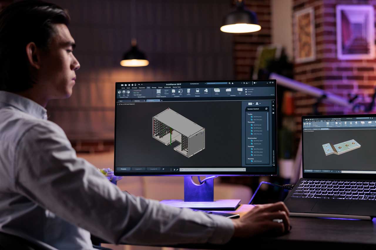 A man works on CAD software from his home computer.