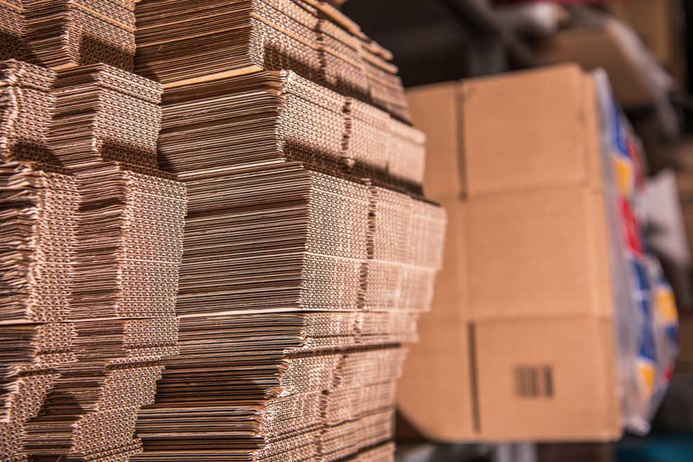 Flat single wall corrugated cardboard sheets stacked in a warehouse