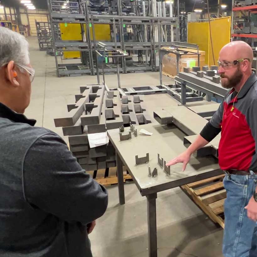 Moffit-Tour-3 Two men have a conversation in a manufacturing facility